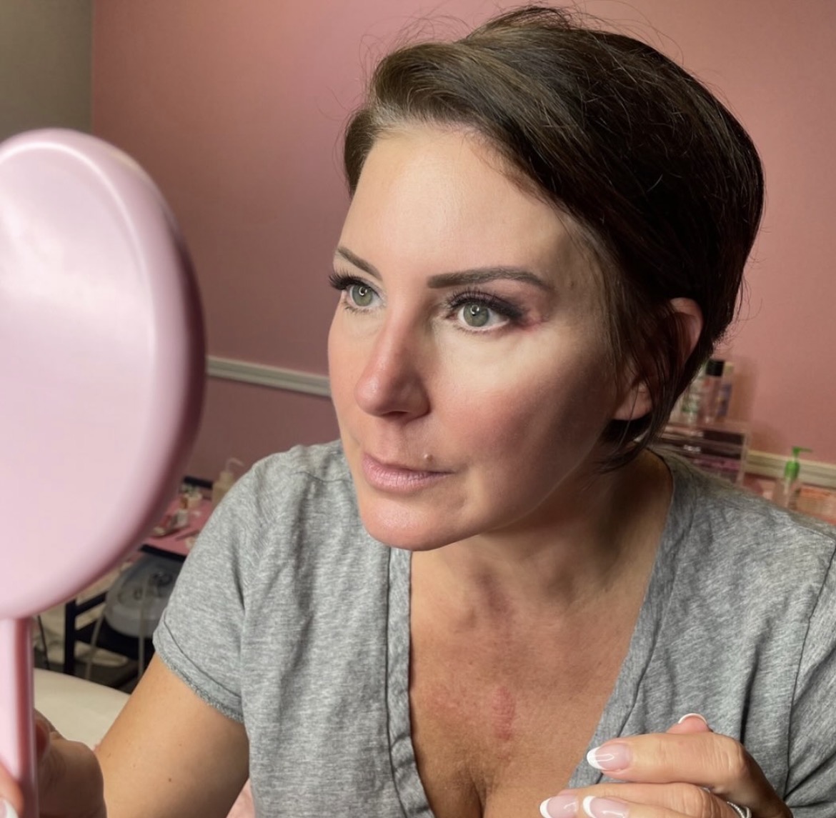 A client checking her lashes in the mirror